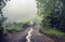 Two hikers on a path throught the forest in the mountains