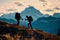 Two hikers are seen climbing a mountain during a beautiful sunset, Comradeship tested as one hiker aids another towards the