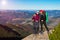 Two Hikers Staying on High Rock and Mountain View with Autumnal Forest