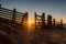 Two hikers stunning dawn sunrise in mountain hills hiker climber climbing wooden fence style silhouette with open gate