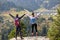 Two hikers at viewpoint in the mountains enjoying beautiful view of the valley with a lake.