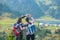 Two hikers at viewpoint in the mountains enjoying beautiful view of the valley with a lake.