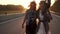 Two hippie girls walk along the freeway at dawn