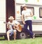 Two hipster friends chilling outdoors. Playing guitar, drinking.