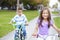 Two Hispanic Children Riding Bikes In Park
