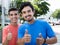 Two hispanic guys showing thumbs in city