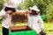 Two hivers in protecting suits opening hive