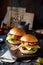 Two homemade burgers with fried chicken, lettuce, cheese, onion, pickled cucumbers, ketchup