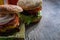 Two homemade burgers on wooden board