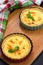 Two homemade quiche with chicken, cheese, cream, onion and mint on wooden background. Above.