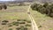 Two horse riders on horseback walking along country track, aerial pull back