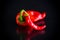 Two hot spicy cayenne peppers on black background