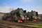 Two huge antique locomotives nex to the garage