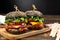 Two huge black hamburgers on dark wooden background