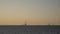 Two huge oil rig silhouettes on the horizon in the open sea, sunset