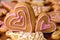 Two icing gingerbread hearts for Valentines Day on the wooden table with others homemade cookies.