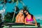 Two incredible beautiful young girls in bikini swimsuits, traveling around a tropical island in a cabriolet off-road car summer