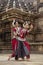 Two Indian classical odissi dancers striking a pose in front of Mukteshvara Temple,Bhubaneswar, Odisha, India