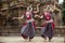 Two Indian classical odissi dancers striking a pose in front of Mukteshvara Temple,Bhubaneswar, Odisha, India