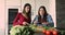 Two Indian women talking while prepare healthy vegetarian salad