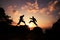 Two individuals engage in karate training, silhouetted against the setting sun