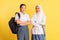 two indonesian high school girls standing carrying bags