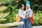 two Indonesian high school girls wearing school bags and smiling to the camera