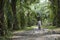 Two Indonesian women carry wood on their heads in a palm trees plantation in Sumatra.