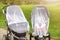 Two infant kids in strollers covered with protective net during walk. Baby carriage with anti-mosquito white cover