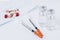 Two insulin syringes with two ampules and some medicine on a white background.