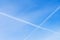 Two intersecting Condensation tracks of airplanes on clear blue sky. With place for your text, for background use.