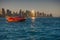 Two jet-skis cruising with the skyline of West Bay in background, at sunset. Doha, Qatar.