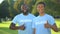 Two joyful american men in volunteer t-shirts showing thumbs up, selfless help