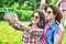 Two joyful fanny pretty girls having fun taking a selfie on mobile