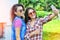 Two joyful fanny pretty girls having fun taking a selfie on mobile