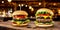 Two juicy cheeseburgers close-up on a wooden table on a kitchen board against a background of a blurred rustic