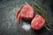 Two juicy filet Mignon beef steaks prepared for grilling with spices and herbs