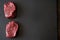 Two juicy, fresh, aged filet mignon steaks on a slate cutting board. Top view from an angle, place for text, cooking premium meat