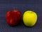 Two juicy large apples red yellow on a woven background with blue rhombuses close-up