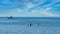 Two Kayakers with Greek fishing boat at anchor in the background off the coast of Lesvos