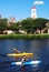 Two Kayakers pass Harvard University`s Dunster House