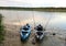 Two kayaks equipped with fishing rods on the shore