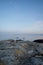 Two kayaks paddlng past Cattle Point during sunset with the moon overhead