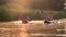 Two kayaks with people rowing into the sunset. Slow motion