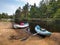 Two kayaks on the sand shore on the background of the forest with oars and things