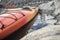 Two kayaks stand moored on the beach, against the background of