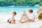 Two kid boys building sand castle on tropical beach