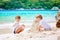 Two kid boys building sand castle on tropical beach