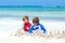 Two kid boys building sand castle on tropical beach of Bora Bora