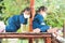 Two kid girls wearing white face mask are playing climbing on playground wooden equipment. To prevent viruses and small toxic dust